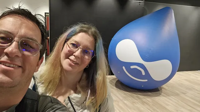 Anilu y camoa in a selfie with the Drupicon behind threm, at DrupalCon Lille 2023